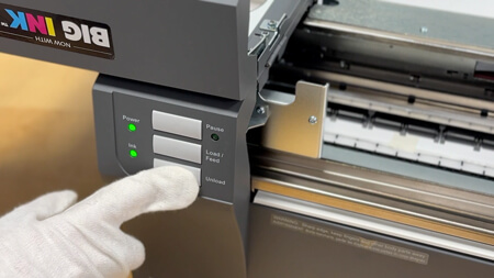 Open the cover and unload the label roll by pressing the unload button.